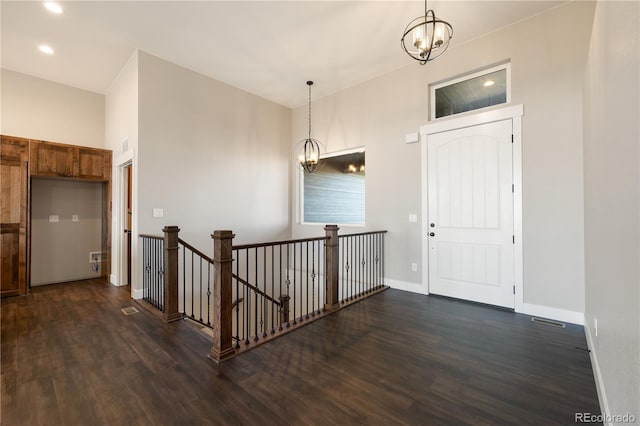 hallway featuring an inviting chandelier and dark hardwood / wood-style floors