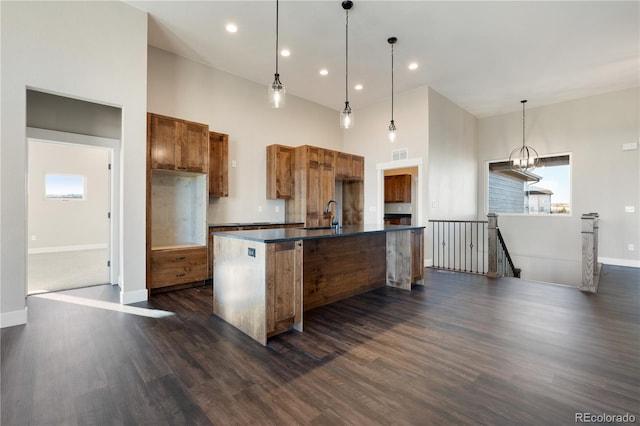 kitchen featuring a healthy amount of sunlight, dark wood-type flooring, and hanging light fixtures