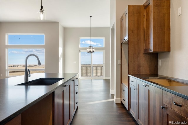 kitchen with a notable chandelier, pendant lighting, a wealth of natural light, and sink