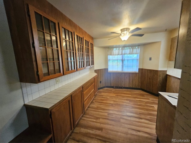 912 E 6th Ave, Broomfield, CO 80020 - unfurnished dining area with wainscoting, wood finished floors, ceiling fan, and wooden walls