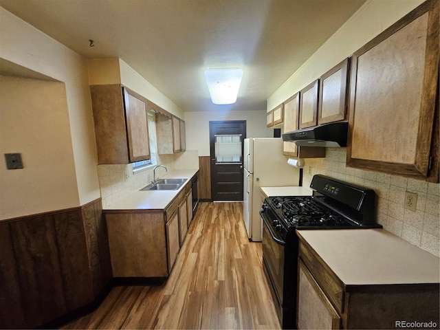 912 E 6th Ave, Broomfield, CO 80020 - kitchen featuring black appliances, under cabinet range hood, a sink, light wood-type flooring, and light countertops
