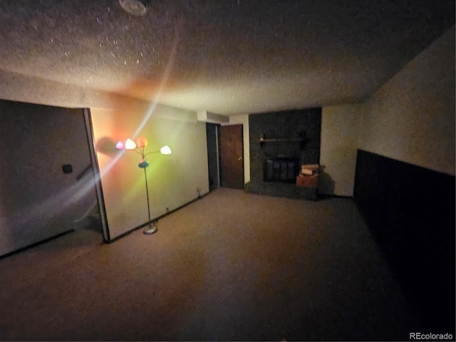 912 E 6th Ave, Broomfield, CO 80020 - unfurnished living room featuring a fireplace, a textured ceiling, and carpet flooring