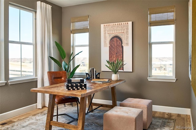 office space with wood finished floors, visible vents, and baseboards