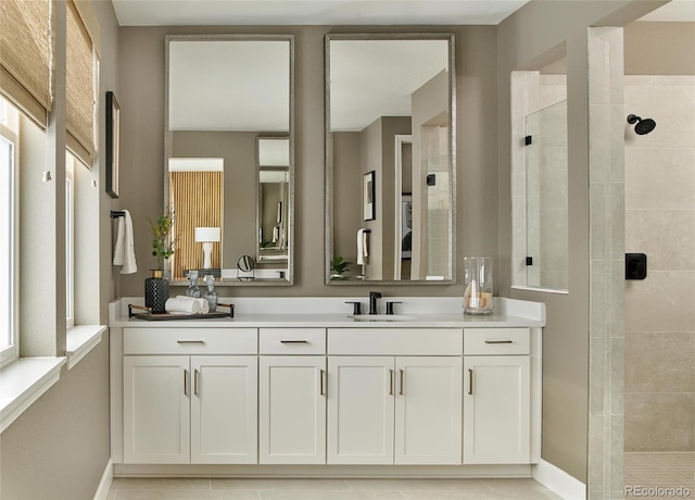 bathroom with walk in shower, vanity, and baseboards