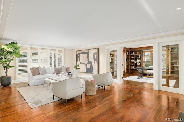 living room featuring hardwood / wood-style flooring, plenty of natural light, crown molding, and french doors