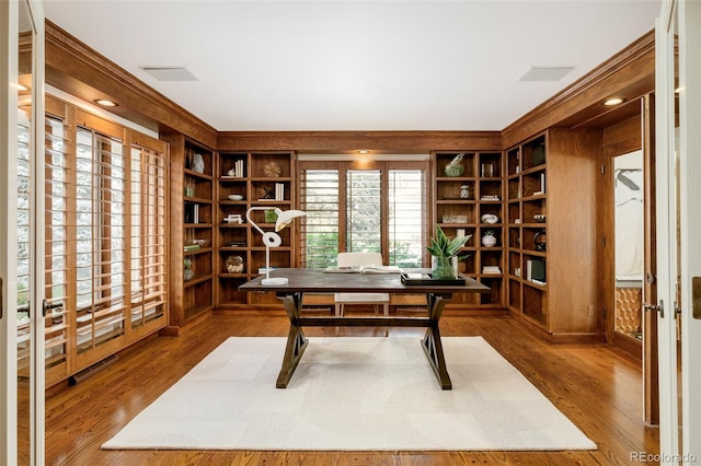 office area featuring crown molding, hardwood / wood-style floors, and built in shelves