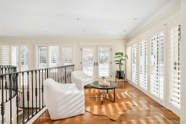 sitting room with french doors, wood-type flooring, and crown molding