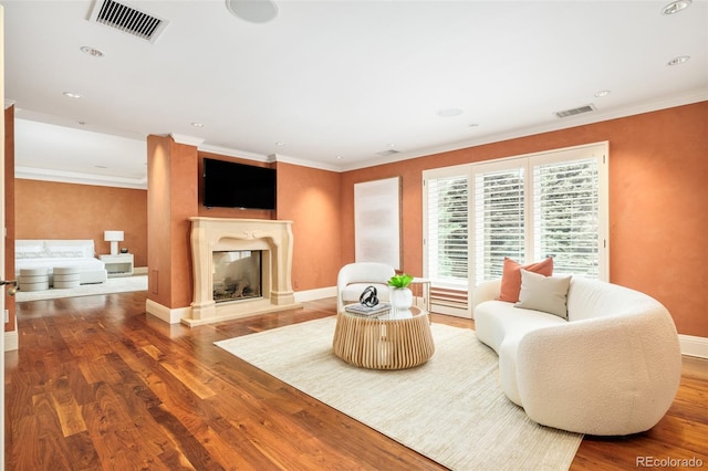 living room with wood-type flooring and ornamental molding