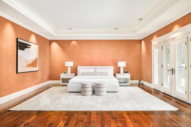 bedroom featuring hardwood / wood-style flooring, access to outside, french doors, and a tray ceiling