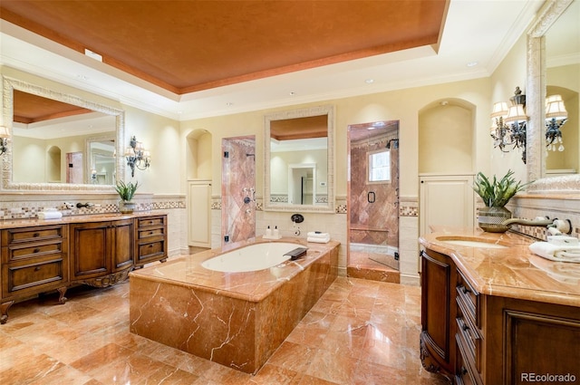 bathroom with shower with separate bathtub, ornamental molding, vanity, and a tray ceiling