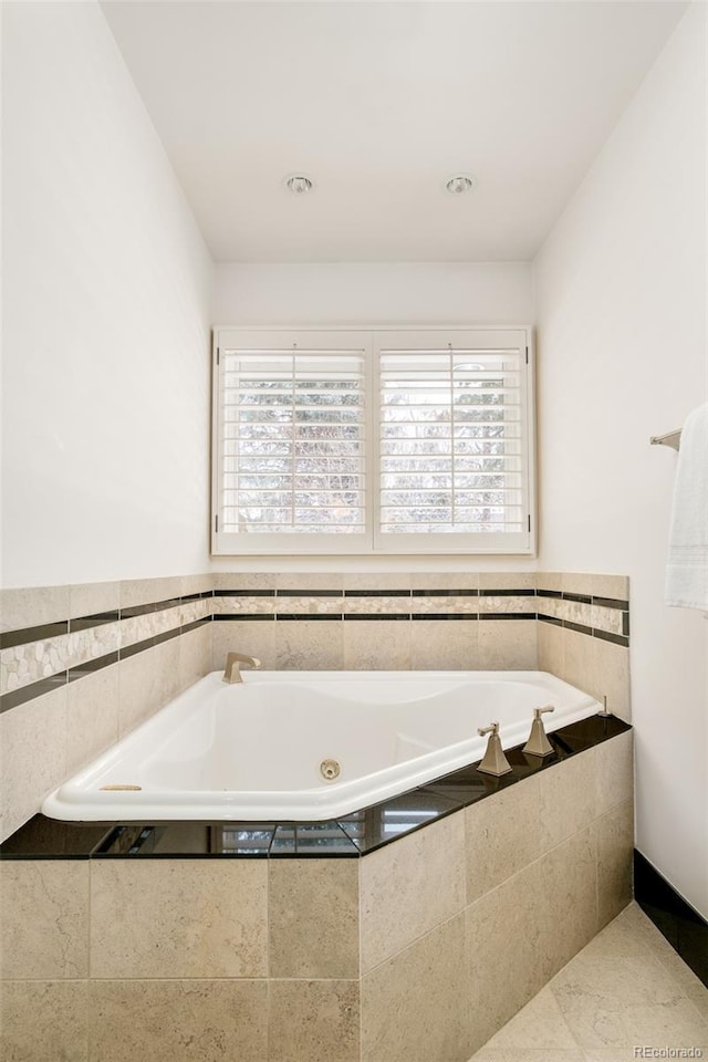 bathroom featuring tile patterned flooring, plenty of natural light, and tiled bath