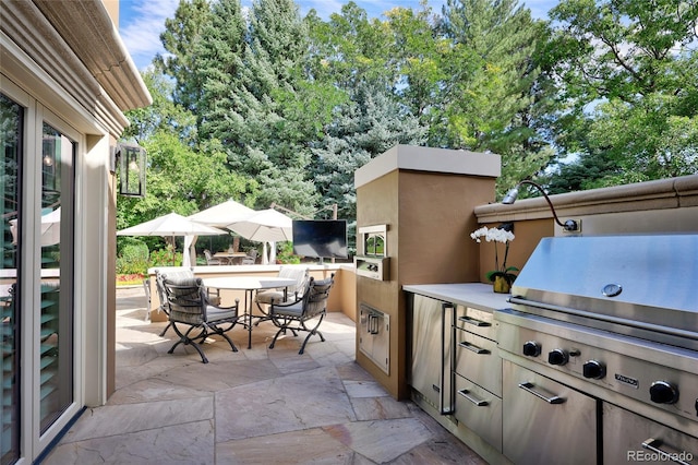 view of patio / terrace with exterior kitchen and a grill