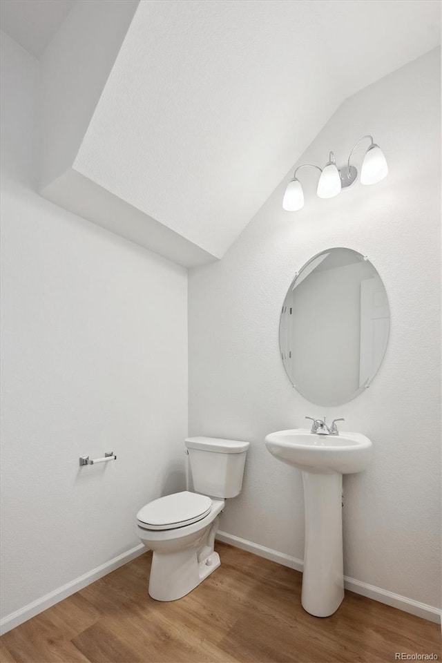 bathroom with hardwood / wood-style flooring, toilet, and sink