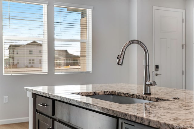 interior space featuring light stone countertops and sink