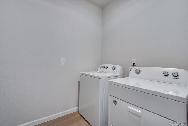 laundry room featuring separate washer and dryer and light wood-type flooring