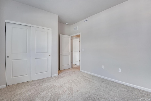 unfurnished bedroom featuring a closet and light carpet