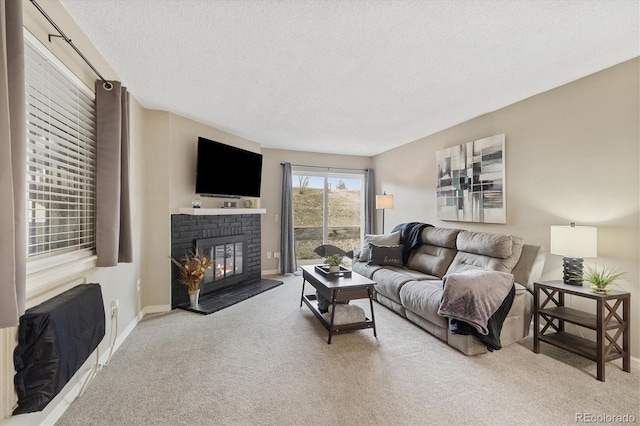 carpeted living area featuring baseboards, a textured ceiling, and a fireplace