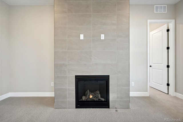 room details featuring carpet floors, visible vents, a fireplace, and baseboards