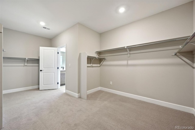 spacious closet featuring visible vents and light colored carpet