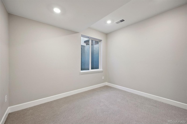 spare room featuring recessed lighting, carpet flooring, visible vents, and baseboards