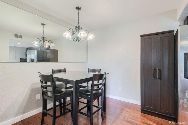 dining area with a chandelier and hardwood / wood-style flooring