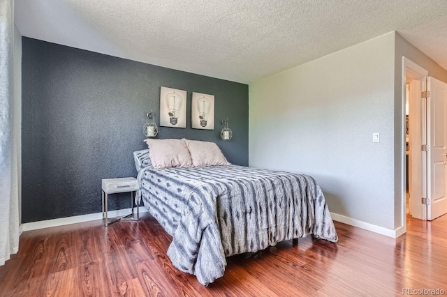 bedroom featuring a textured ceiling and wood-type flooring