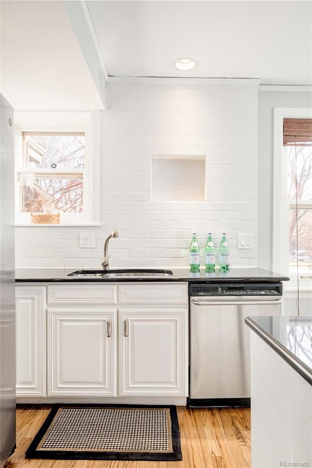 kitchen with light hardwood / wood-style floors, sink, white cabinetry, and stainless steel dishwasher