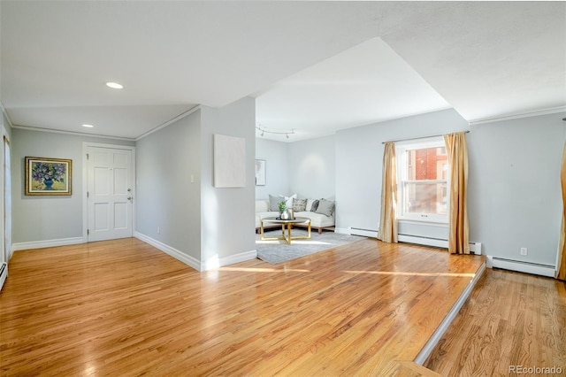 foyer entrance with a baseboard heating unit, ornamental molding, and light hardwood / wood-style floors