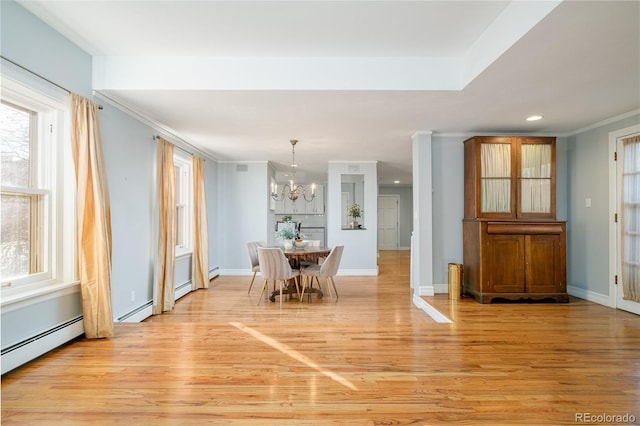 dining area with baseboard heating, a chandelier, light hardwood / wood-style floors, and ornamental molding