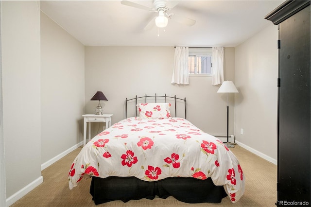 bedroom featuring a baseboard heating unit, ceiling fan, and light colored carpet