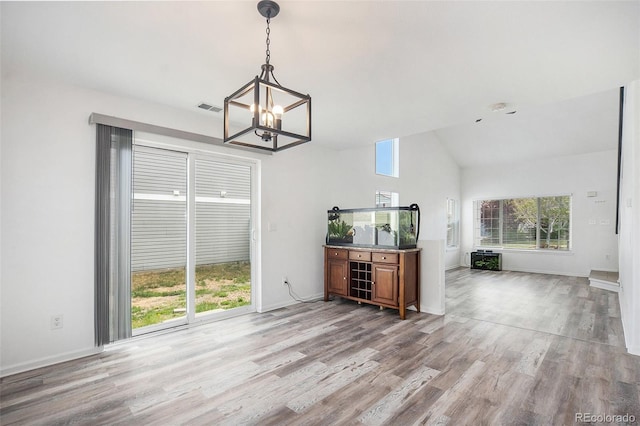 dining room featuring visible vents, baseboards, high vaulted ceiling, light wood-type flooring, and a notable chandelier