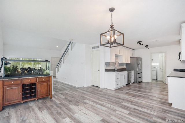 kitchen with visible vents, washer / dryer, a notable chandelier, and light wood-type flooring