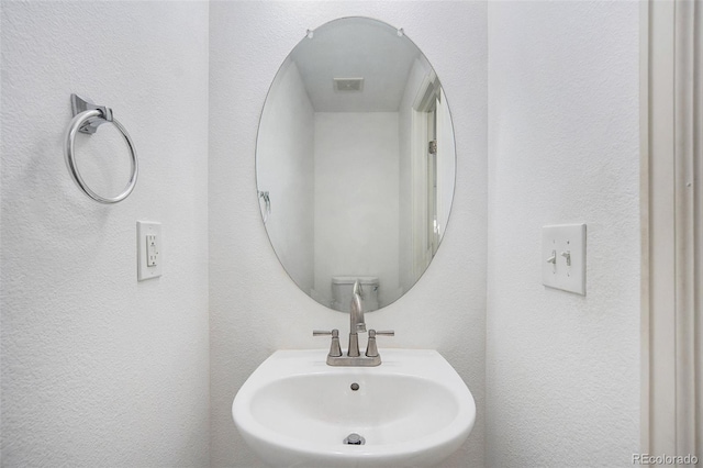 bathroom featuring visible vents and a sink