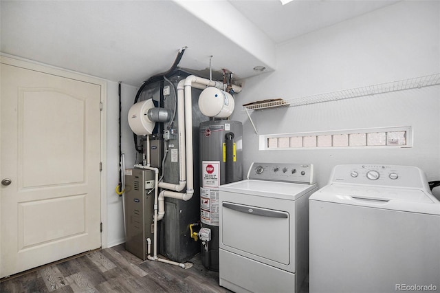 washroom featuring laundry area, washer and clothes dryer, dark wood-style flooring, and gas water heater