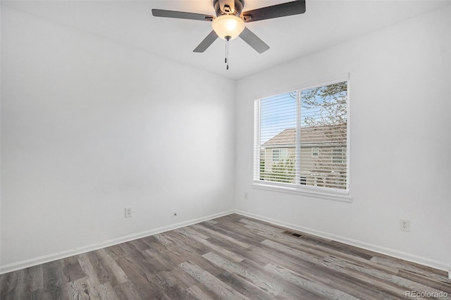 unfurnished room with visible vents, a ceiling fan, baseboards, and wood finished floors
