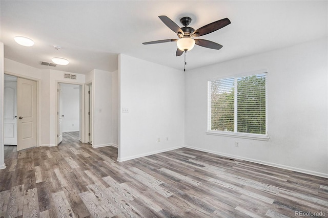 empty room with visible vents, ceiling fan, and wood finished floors