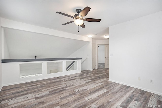 interior space featuring baseboards, a ceiling fan, and wood finished floors