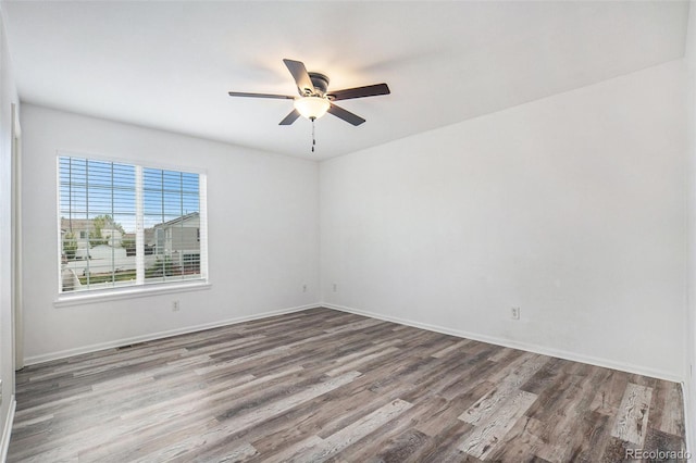 empty room featuring a ceiling fan, baseboards, and wood finished floors