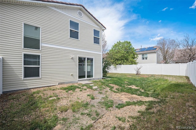 back of house with a lawn and fence