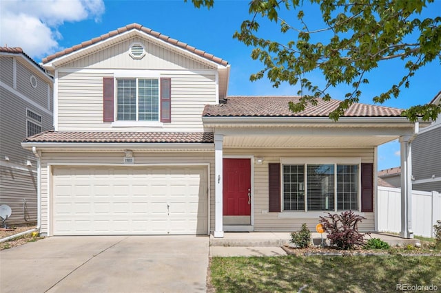 view of front of house featuring an attached garage, fence, driveway, and a tile roof