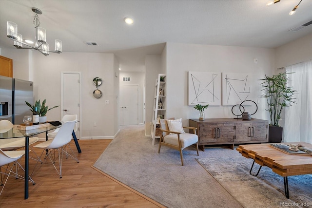 living room featuring a chandelier and light hardwood / wood-style floors