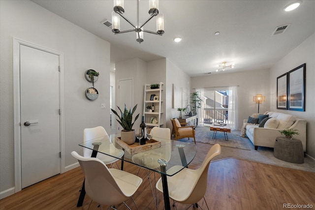 dining room featuring hardwood / wood-style flooring and a chandelier