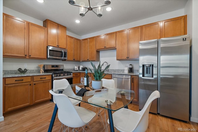 1841 S Dunkirk St Unit 203, Aurora, CO 80017 - kitchen with stainless steel appliances, light wood-style flooring, a chandelier, light stone countertops, and recessed lighting
