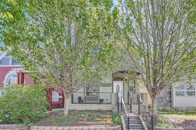 obstructed view of property featuring brick siding and stucco siding