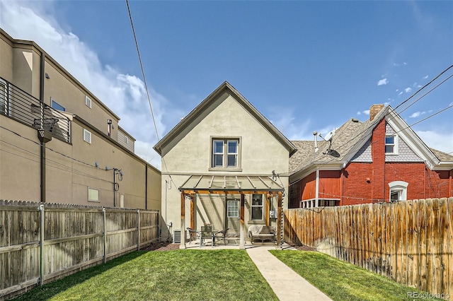 rear view of house with a lawn, a patio, a fenced backyard, and stucco siding