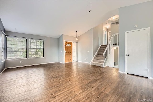 18984 E Kent Cir, Aurora, CO 80013 - unfurnished living room featuring stairs, wood finished floors, baseboards, and high vaulted ceiling