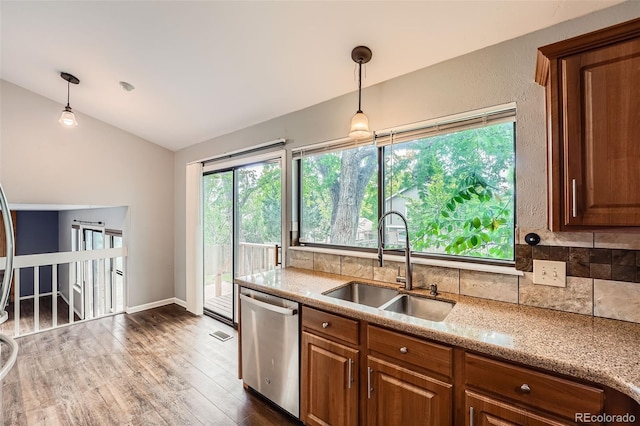 18984 E Kent Cir, Aurora, CO 80013 - kitchen with a sink, dishwasher, vaulted ceiling, backsplash, and hanging light fixtures