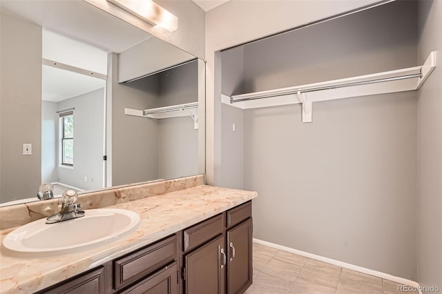 18984 E Kent Cir, Aurora, CO 80013 - bathroom with vanity, a walk in closet, tile patterned floors, and baseboards