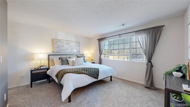 bedroom with a textured ceiling, carpet, visible vents, and baseboards