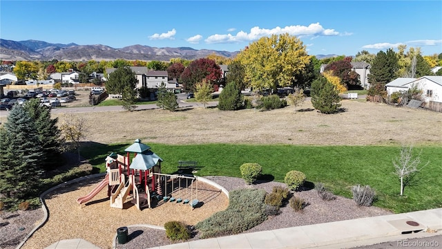 view of yard featuring a playground and a mountain view